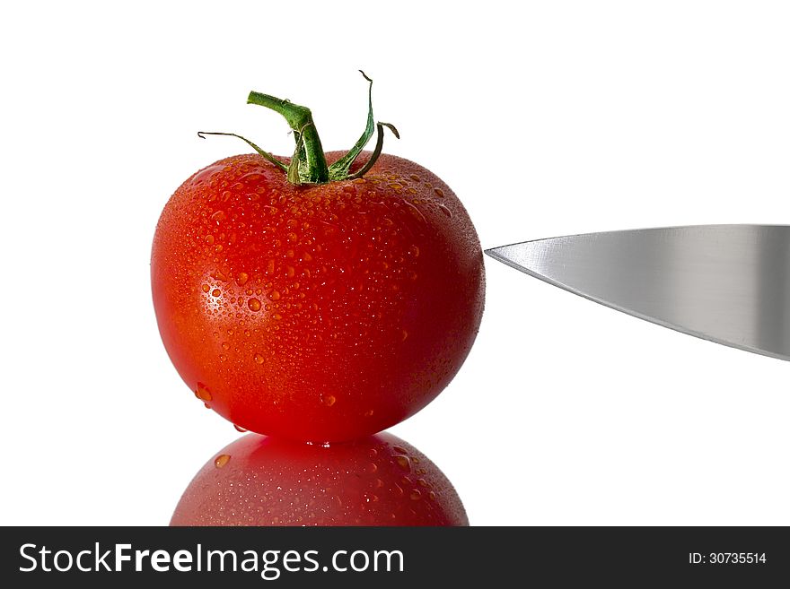 Tomato with water droplets and sharp knife. Tomato with water droplets and sharp knife.