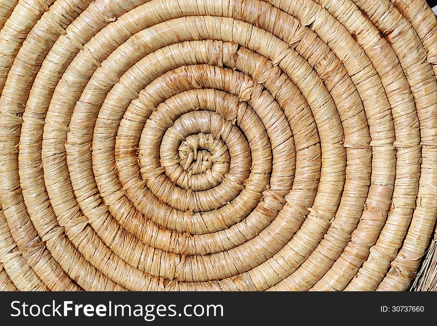 A background of a closeup spiral straw mat. A background of a closeup spiral straw mat