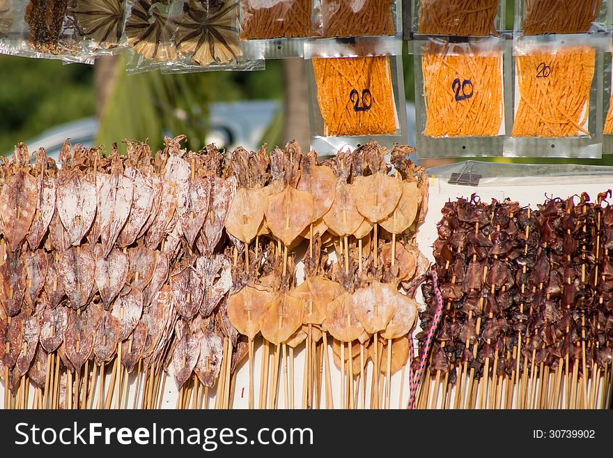 Dried squid skewers a row for sale. Dried squid skewers a row for sale.