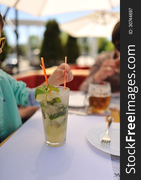 Close-up of a glass of cold drink mojitos with colored straws