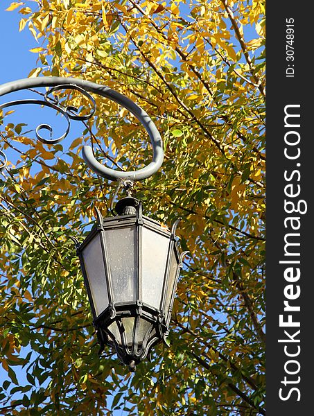 Old lamp against autumn foliage