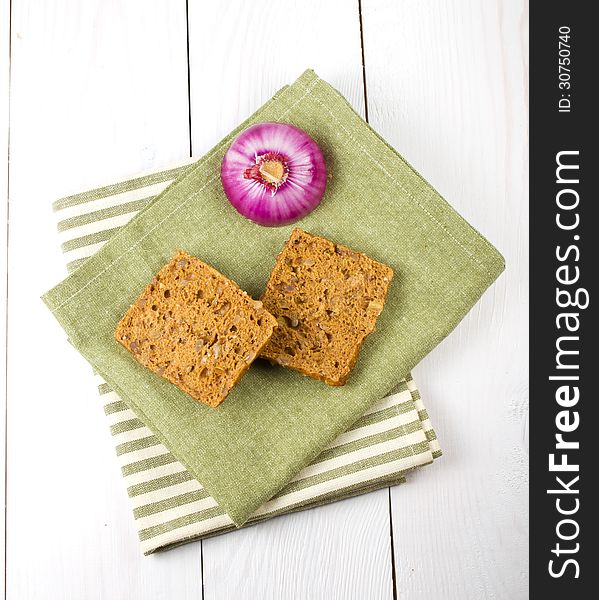 Bread slices and onion on napkins, on wooden background. Bread slices and onion on napkins, on wooden background