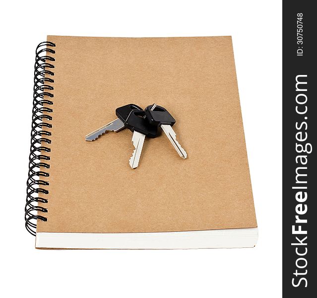 Recycled paper notebook front cover and car keys isolated on white background. Recycled paper notebook front cover and car keys isolated on white background