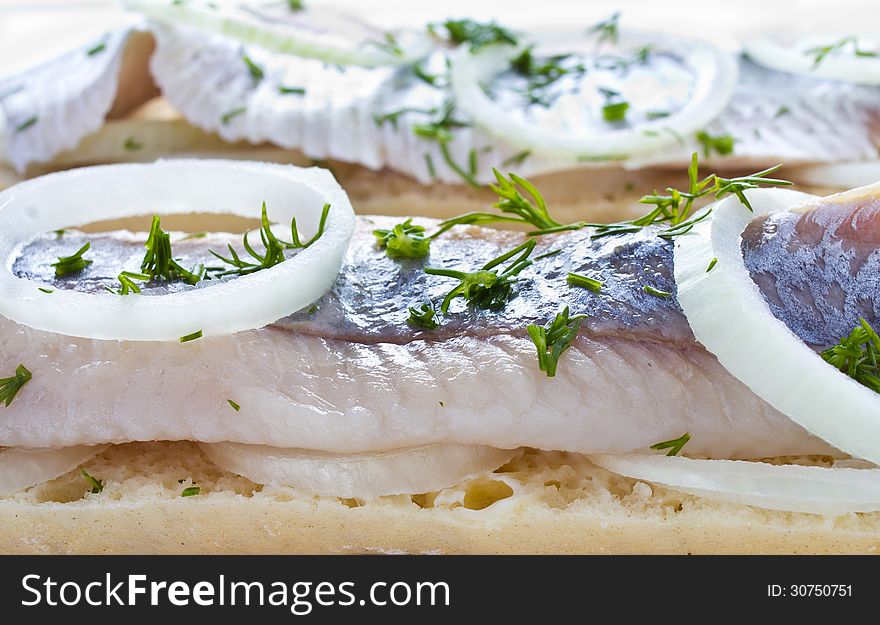 Sandwiches with herring, onions and herbs, closeup