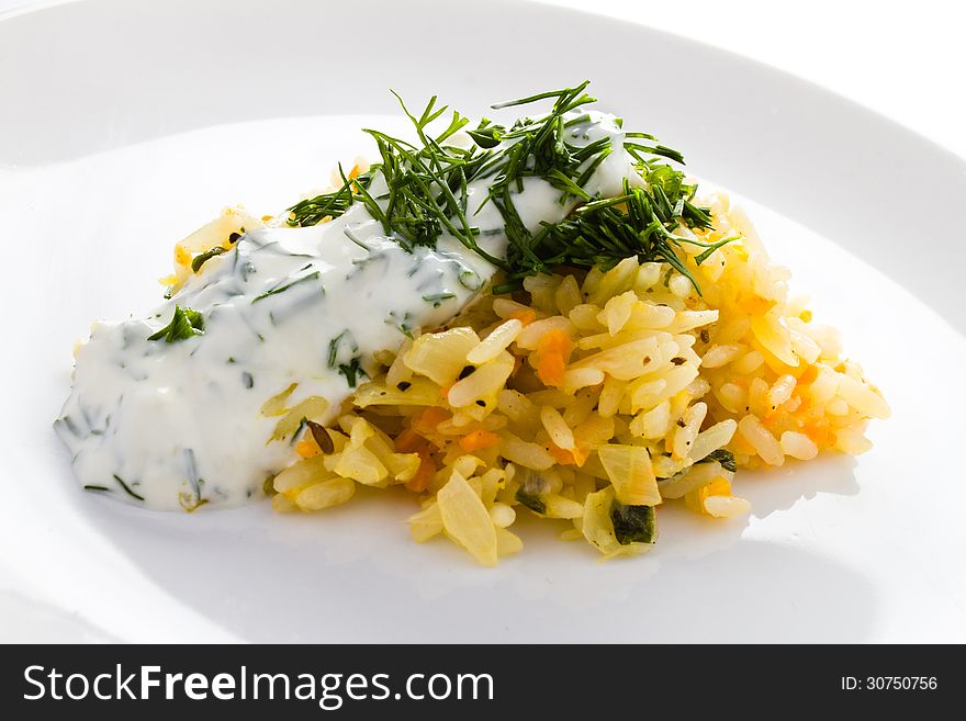 White rice with garlic sauce on a plate on white background