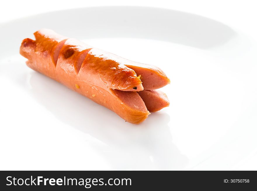 Grilled sausage on a plate on white background. Grilled sausage on a plate on white background