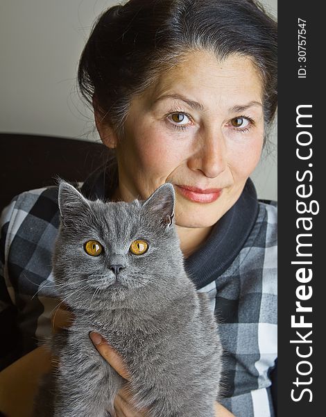 Pretty woman with a gray cat British breed. Pretty woman with a gray cat British breed