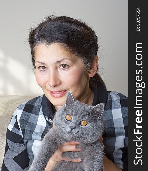 Pretty woman with a gray cat British breed. Pretty woman with a gray cat British breed