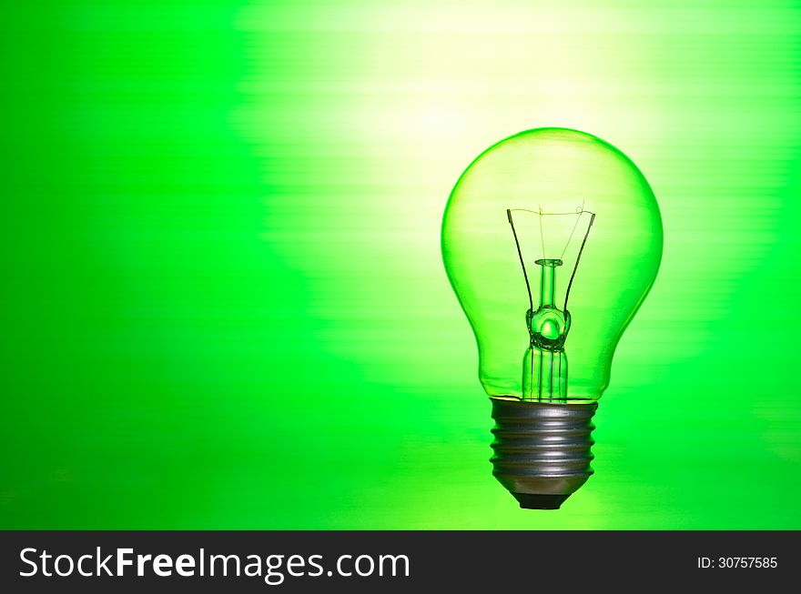 Lamp over green background as eco energy concept