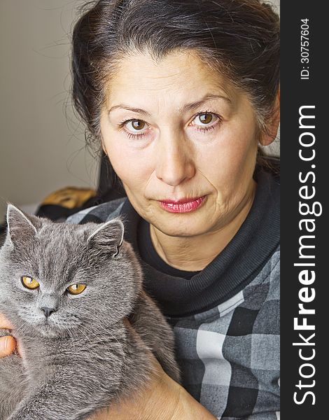 Pretty woman with a gray cat British breed. Pretty woman with a gray cat British breed