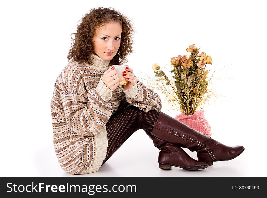 Beautiful girl sitting in a sweater with a mug of tea