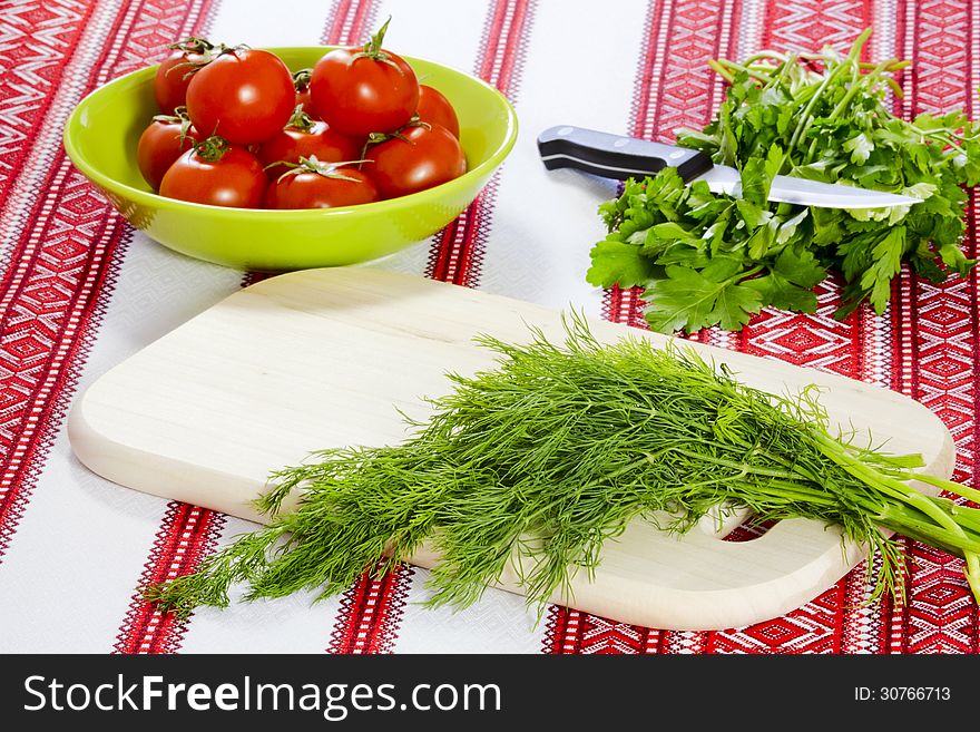 On a cutting board dill and parsley and ripe tomatoes. On a cutting board dill and parsley and ripe tomatoes