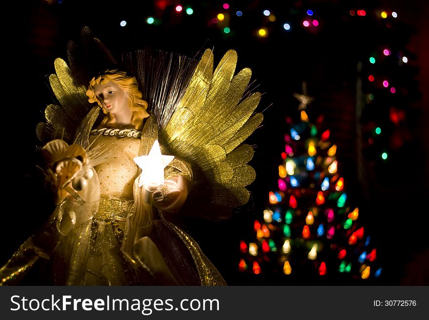 Angel tree topper with illuminated tree.