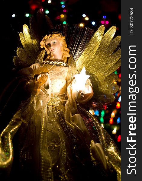 Angel tree topper with illuminated tree.