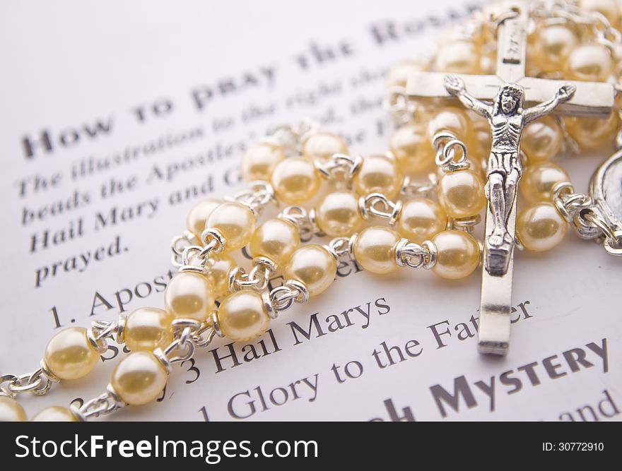 Closeup of a rosary on instructions. Closeup of a rosary on instructions.