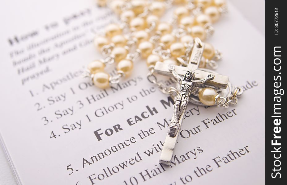Closeup of a rosary on instructions. Closeup of a rosary on instructions.
