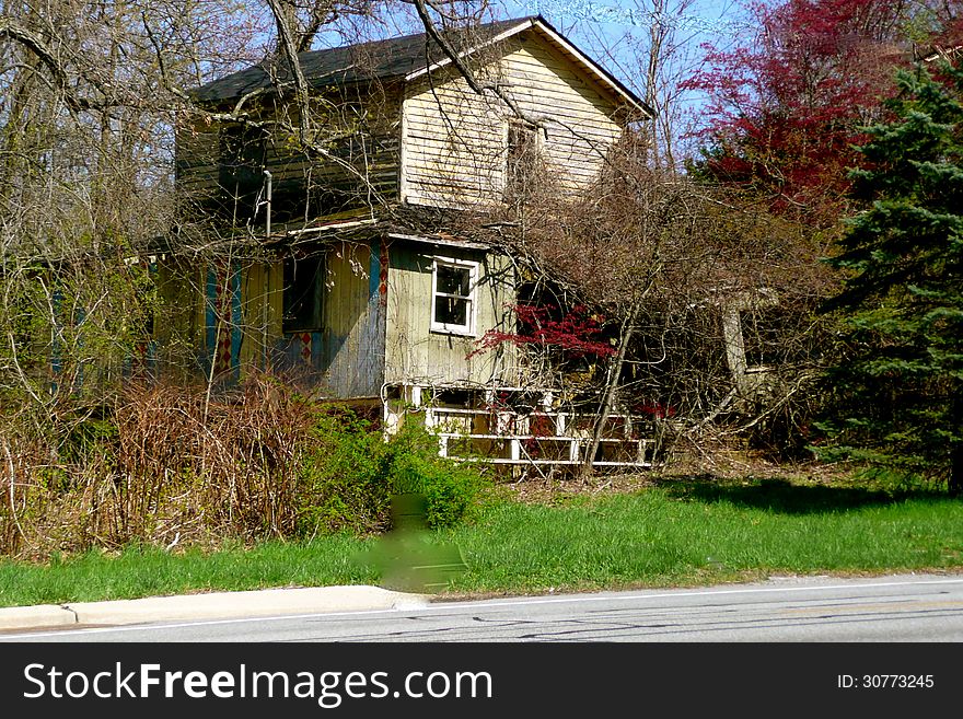 A house stands abandoned on side of the road. A house stands abandoned on side of the road