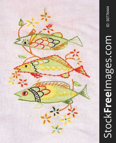 White cloth with intricate embroidery of fishes. White cloth with intricate embroidery of fishes.