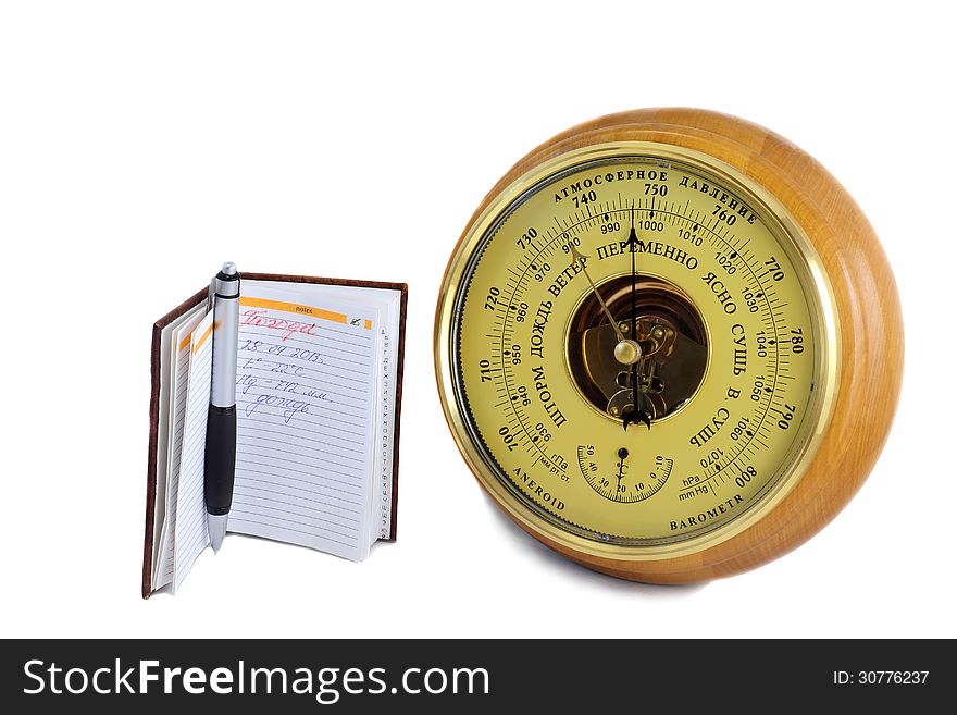 Barometer in the frames of wood and a notebook for recording of meteorological data . Presented on a white background. Barometer in the frames of wood and a notebook for recording of meteorological data . Presented on a white background.