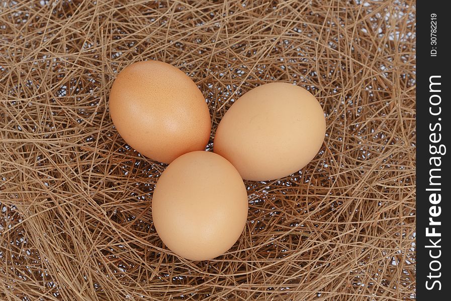 Three eggs on hay nest background. Three eggs on hay nest background