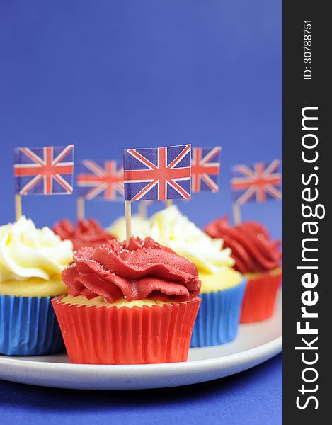 English theme red, white and blue cupcakes with Great Britain Union Jack flags - Close up vertical.