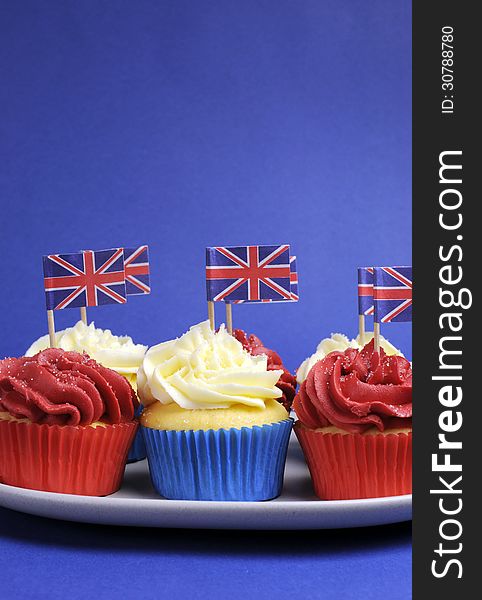 English theme red, white and blue cupcakes with Great Britain Union Jack flags - vertical with copy space.