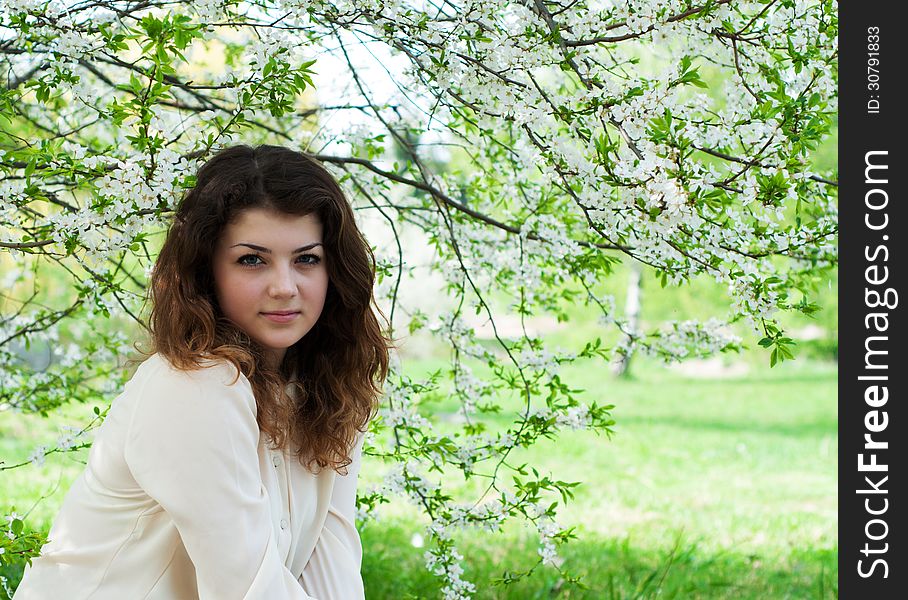 Portrait of young brunette in the spring garden. Portrait of young brunette in the spring garden