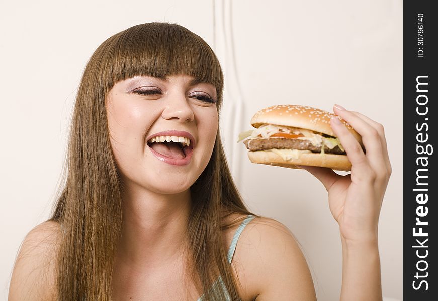 Portrait of young pretty woman with burger on white background