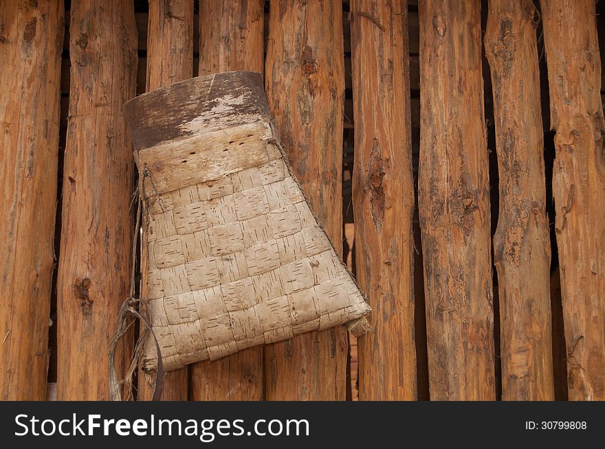 Bag from birch bark for firewoods on the wooden wall russia national