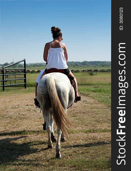 This girl is relaxing while riding on the back of her horse. This girl is relaxing while riding on the back of her horse.