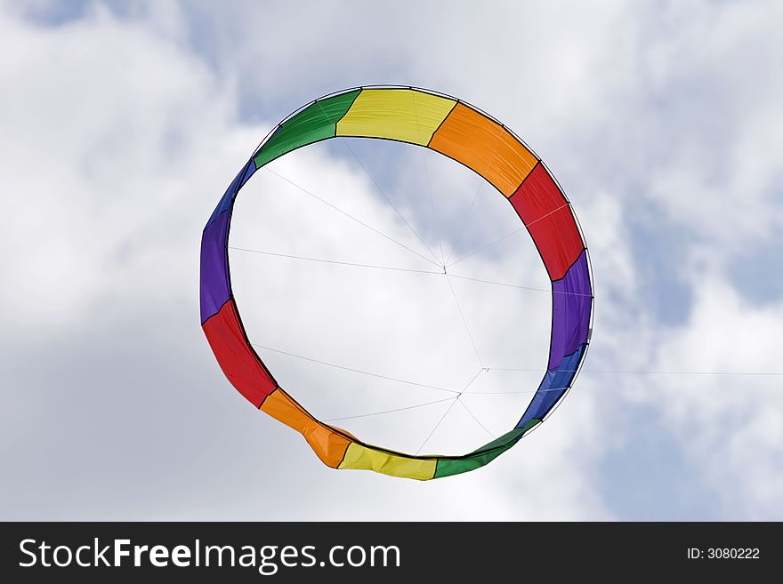 A circular shaped kite flying in the sky. A circular shaped kite flying in the sky