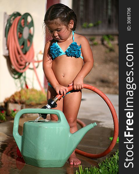 Young Child playing outdoors with water and bucket. Young Child playing outdoors with water and bucket