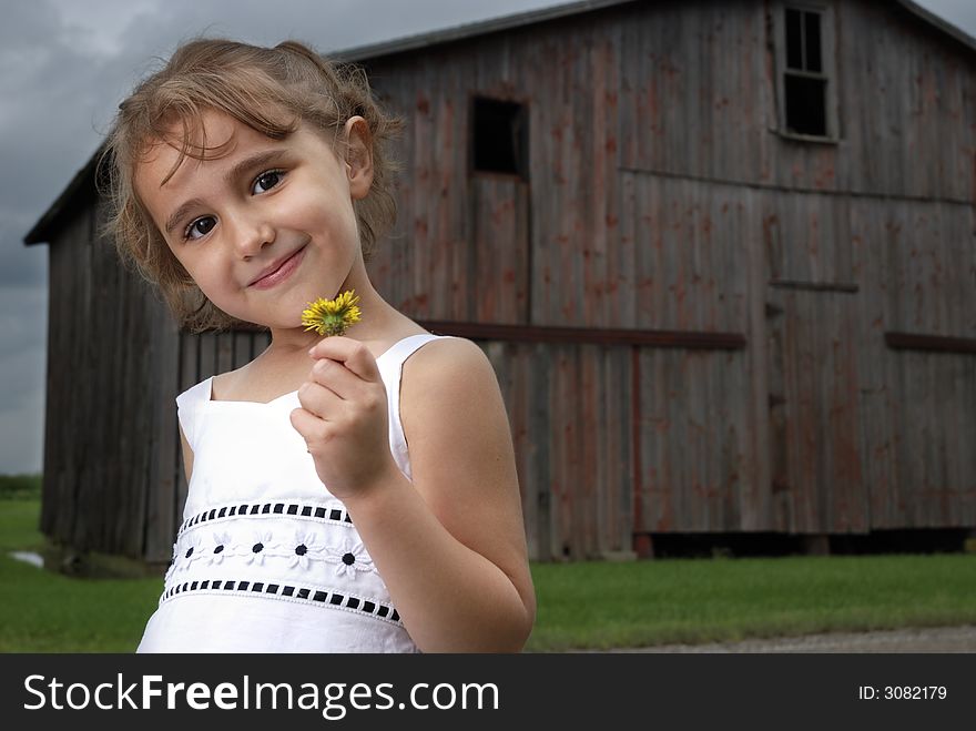 Girl in front of weathered barn with stormy sky background. Girl in front of weathered barn with stormy sky background