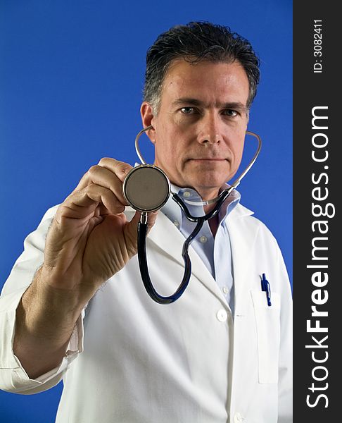 A picture of a man with a stethoscope, with the end of the stethoscope being the focus. A picture of a man with a stethoscope, with the end of the stethoscope being the focus.