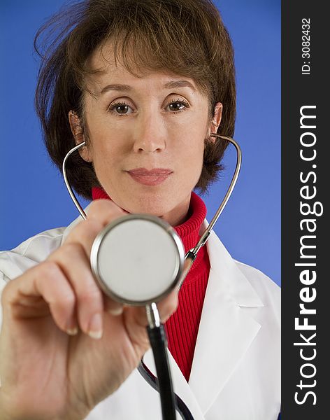 A woman with a stethoscope in her hand acting as if she is going to examine a patient. (focus on the face). A woman with a stethoscope in her hand acting as if she is going to examine a patient. (focus on the face)
