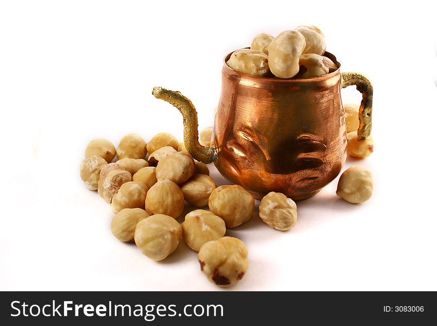 Hazelnuts lying around cupper cup. Hazelnuts lying around cupper cup