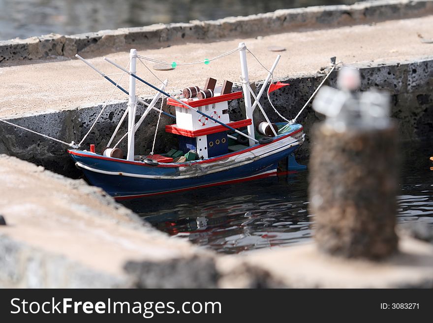 Miniature wooden fish boat at port quay