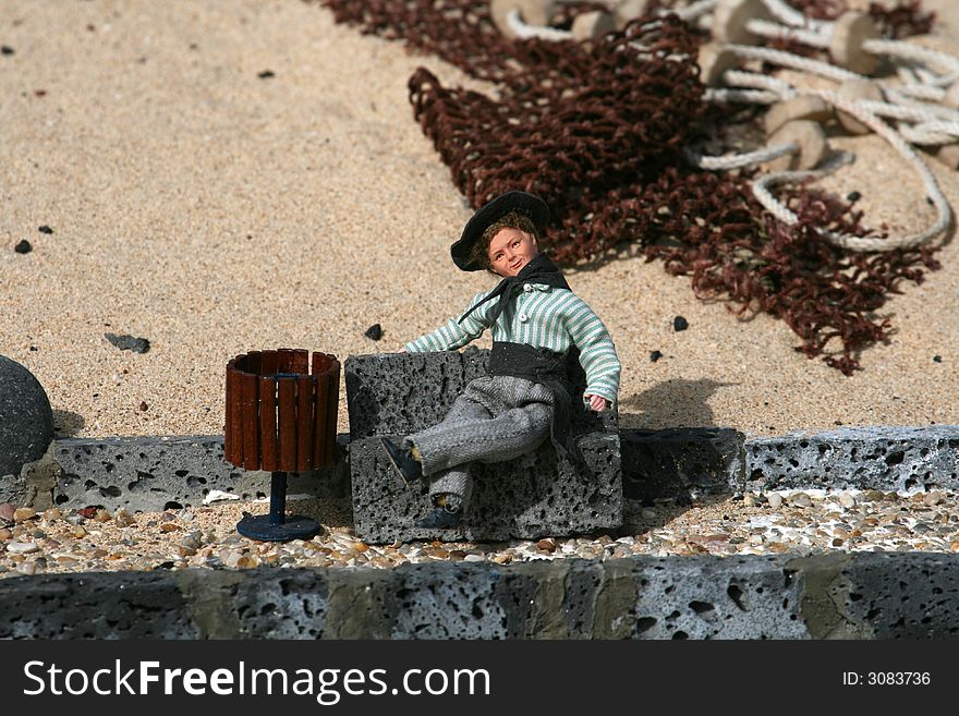 Miniature figurine of a fisherman on a bench