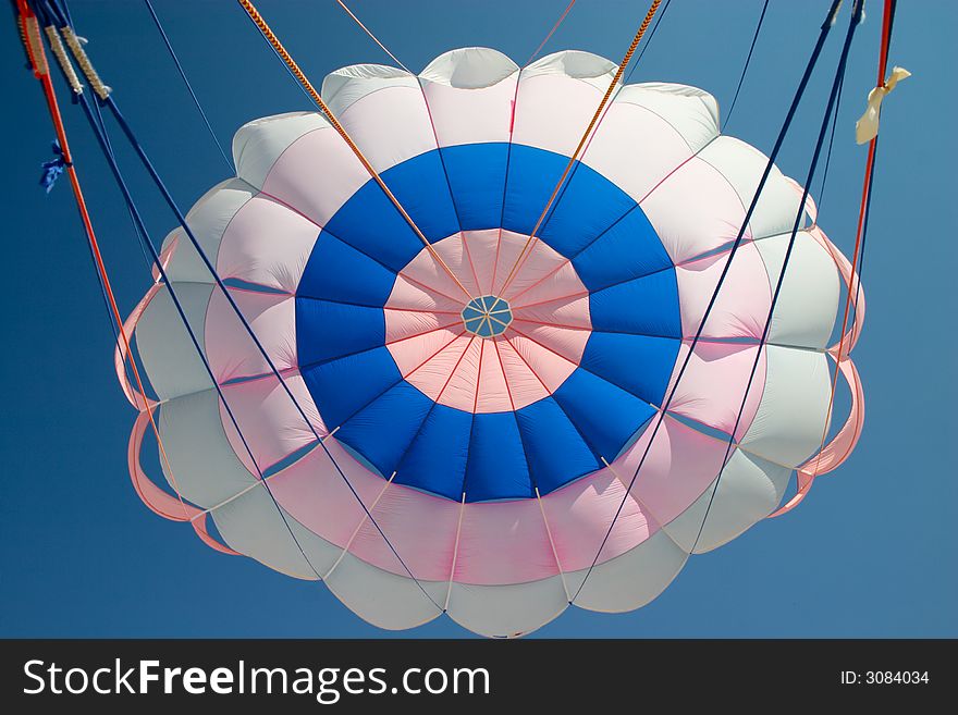 Colorful parachute on the background of blue sky