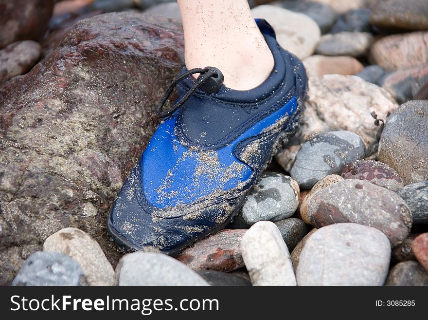 A childs foot standing on rocks