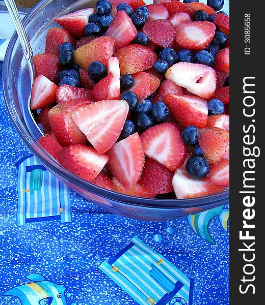 Fresh blueberries and strawberries in glass bowl on a fun tablecloth. Fresh blueberries and strawberries in glass bowl on a fun tablecloth.