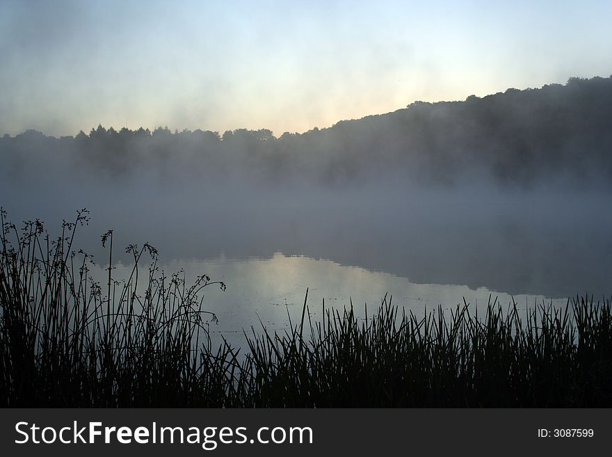 Early dawn on lake in fog and mist. Early dawn on lake in fog and mist