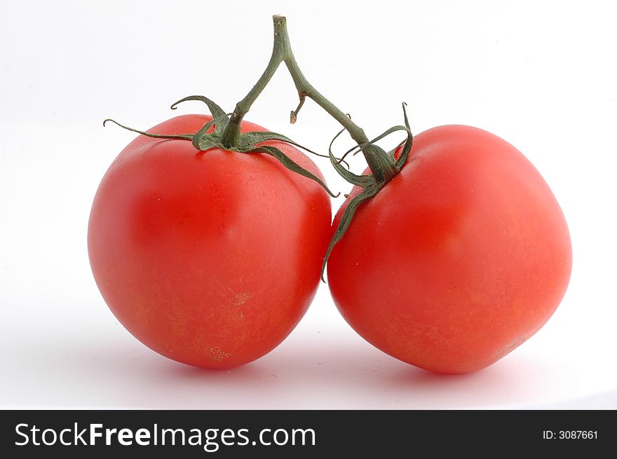 Two tomatoes of a white background