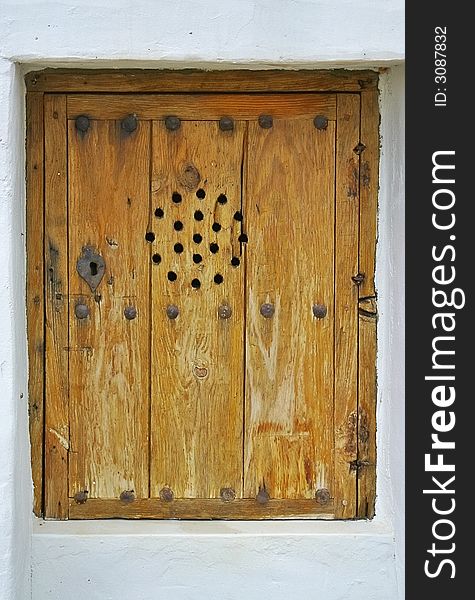 Brown wodd window of an rustic house in Ibiza, Spain