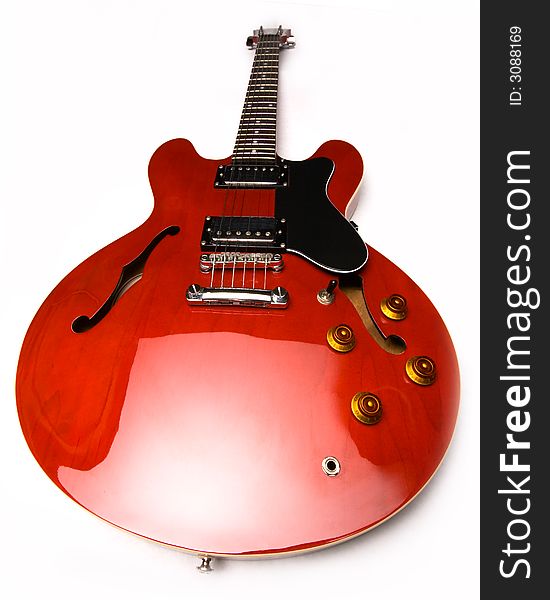 Wide angle of red electric guitar laying on white background