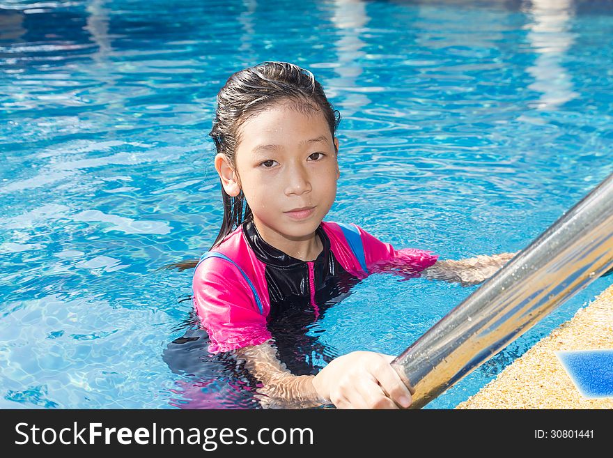 Girl relaxing on the side of a swimming pool. Girl relaxing on the side of a swimming pool