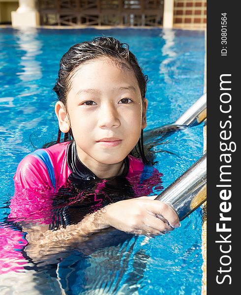 Girl relaxing on the side of a swimming pool. Girl relaxing on the side of a swimming pool