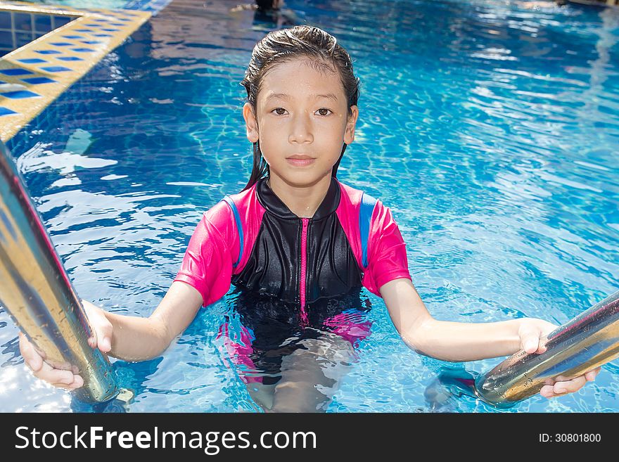 Girl relaxing on the side of a swimming pool. Girl relaxing on the side of a swimming pool