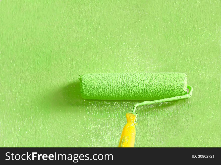 Wall painter using a paint roller painting a wall. Wall painter using a paint roller painting a wall