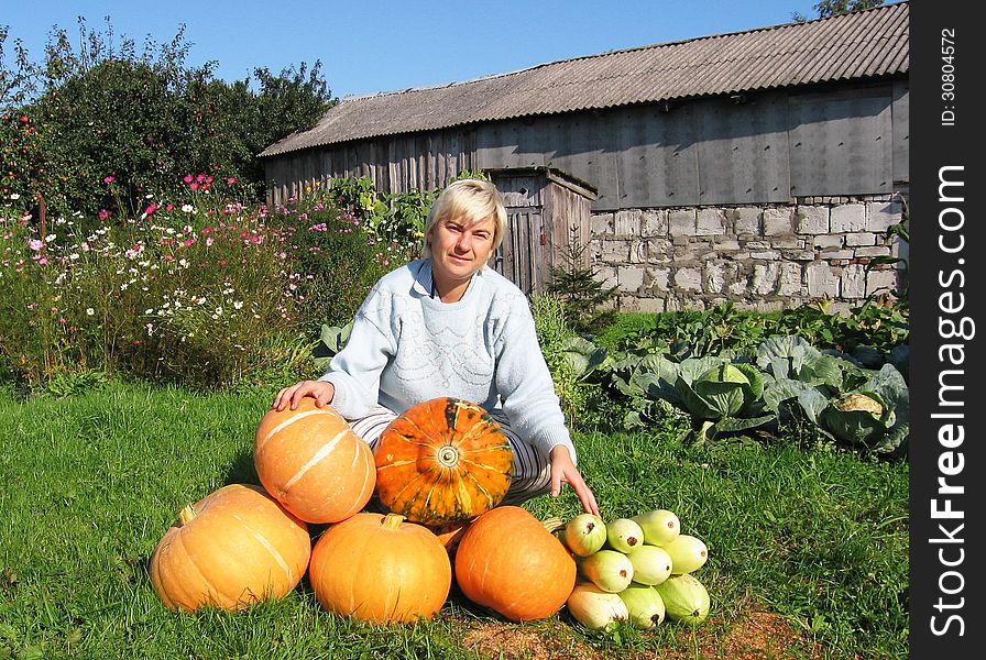 Woman with a crop of pumpkins and squash on her farm